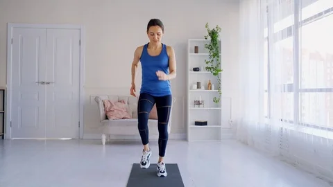 A girl performs an exercise Jogging in place to burn fat. Stock Footage 127012659