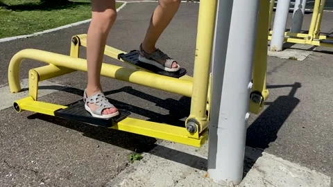 Girl performs exercises on a leg trainer, running and walking, stepper Video stock 158928002