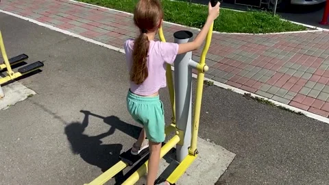 Girl performs exercises on a leg trainer, running and walking Vidéo 158928032