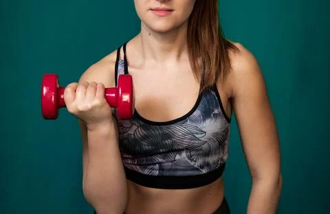 Girl performs exercises using dumbbells. Stock Photos