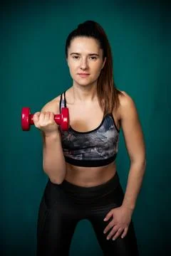 Girl performs exercises using dumbbells. Stock Photos