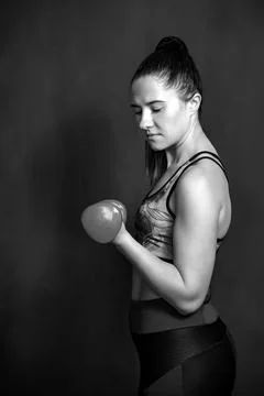 Girl performs exercises using dumbbells. Stock Photos