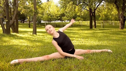 Girl performs gymnastic exercises in nature Stock Footage