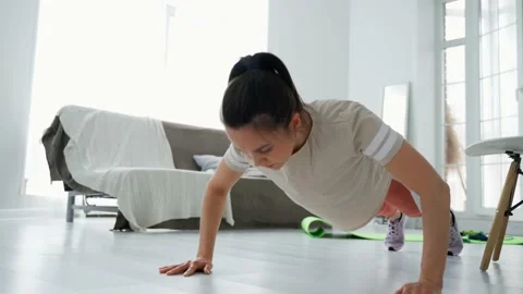 The girl performs push-ups from the floor. The girl conducts distance fitness Stock Footage 153647640