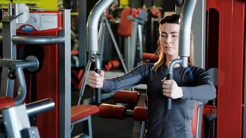 The girl performs strength exercises on the simulator Video stock 106730153