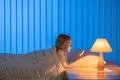The girl with a phone lay on the bed. Evening night time Photo