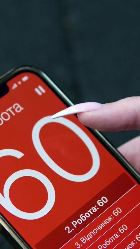 Girl on phone set timer 60 seconds hold phone in hands long manicure getting Stock Footage 317812989