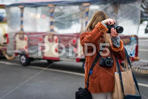 Girl photographer takes pictures. Neck hang two cameras Stock Photos