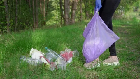 Girl pick up trash doing plogging.Plogging concept. Collecting the litter in Stock Footage 196243269