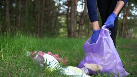 Girl pick up trash doing plogging.Plogging concept. Collecting the litter in Stock Footage 258491629