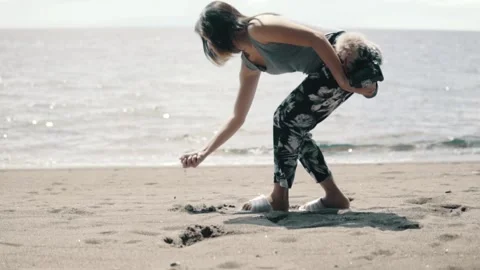 Girl Picking Sand on the Beach Stock Footage 159798716