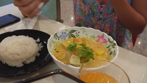 Girl picking up soup in the spoon. Eats soup with greenery. Plate of rice. Vídeos de archivo 106834066