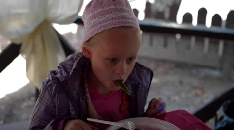 Girl on a picnic eats at the table Stock Footage 55544165