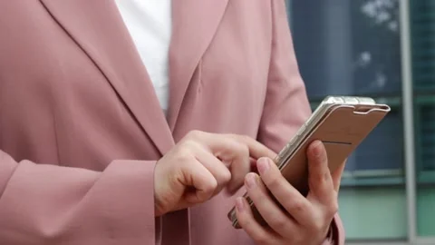 A girl in a pink jacket prints a message on smartphone close-up. Stock Footage 153392745
