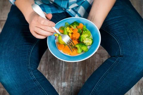 Girl with a plate of vegetables in hands Stock Photos