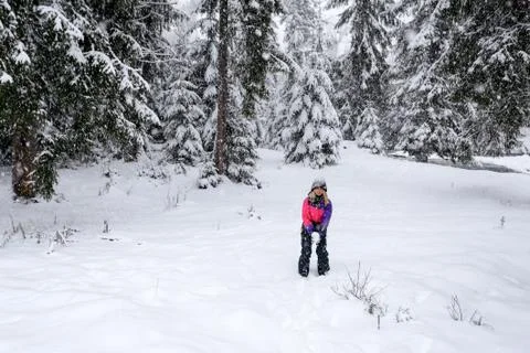 Girl play snowballs in winter snow-covered forest Stock-Fotos