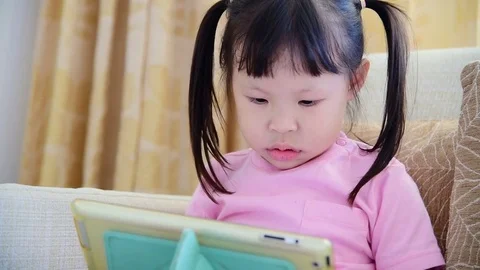 Girl play tablet computer games Stock Footage 74990191