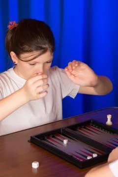 Girl playing a board game called Backgammon Stock Photos