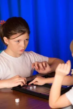 Girl playing a board game called Backgammon Foto stock