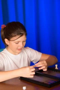 Girl playing a board game called Backgammon Stock Photos