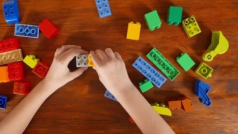 Girl playing in the colored blocks at the table Stock Footage 70789293