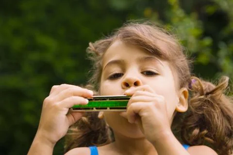 A girl playing the harmonica Stock Photos