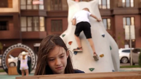 A girl is playing interactive games on the playground in the modern courtyard. Stock Footage 315092826