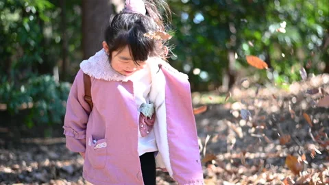 Girl playing with a large amount of fallen leaves Stock-Footage 170752333