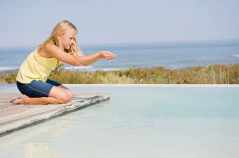 Girl playing on a platform at an infinity pool Stock Photos