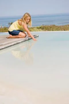 Girl playing on a platform at an infinity pool Stock Photos