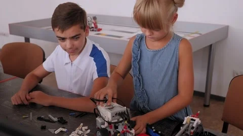 A girl is playing with a robot made from a construction kit at a robotics school Stock Footage 142010714