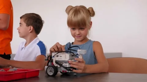 A girl is playing with a robot made from a construction kit at a robotics school Stock Footage 142077893
