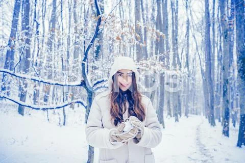 Girl playing with snow in park. Winter woman clothes. Winter woman snow. Winter Stock Photos