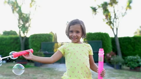 Girl playing with soap bubbles at sunset Stock Footage 142464696