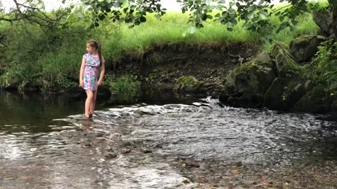 Girl playing in stream Stock Footage 112981470