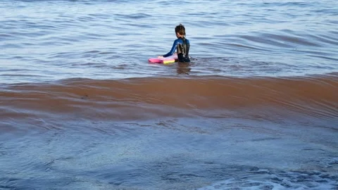Girl playing in surf Vidéo 132050189