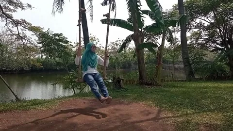 A girl playing on a swing Stock Footage 157012749