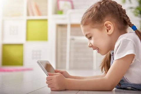 Girl playing in tablet computer Stock Photos
