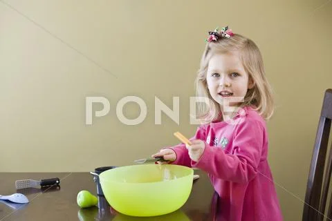 A girl playing with toy food and cooking utensils Stock Photos