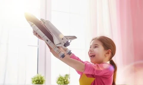 Girl playing with toy rocket Stock Photos
