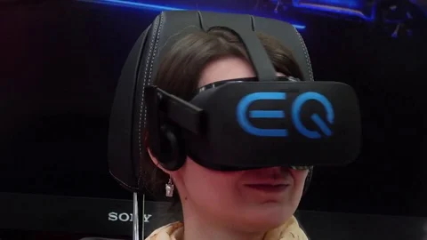 Girl playing video game in Oculus virtual reality headset on exhibition Cebit Stock Footage