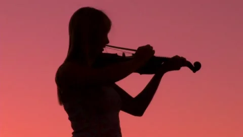 Girl playing violin ms sunset Stock Footage