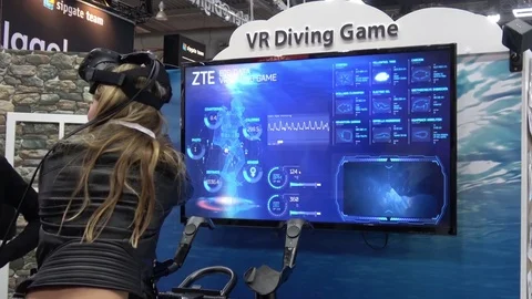 Girl playing VR diving game in virtual reality headset developed by HTC Vive on Stock Footage 76330220