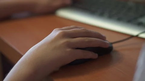 A girl plays on the computer and drives the table with a computer mouse Stock Footage 106957334