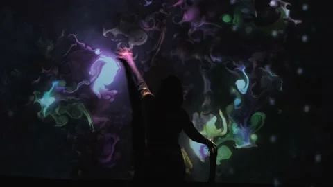 Girl plays with interactive video installation, hands draw the shape heart. New Stock Footage 138927885
