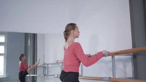 Girl in pointe doing a warm-up at the ballet choreographic machine  Stock Footage 106539695