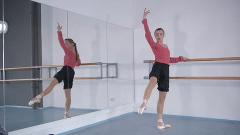 Girl in pointe doing a warm-up at the ballet choreographic machine  Vídeo Stock 106539773