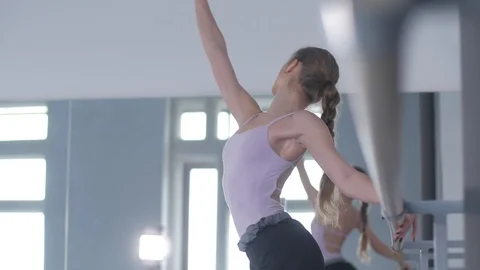 Girl in pointe doing a warm-up at the ballet choreographic machine  Stock Footage 106539796