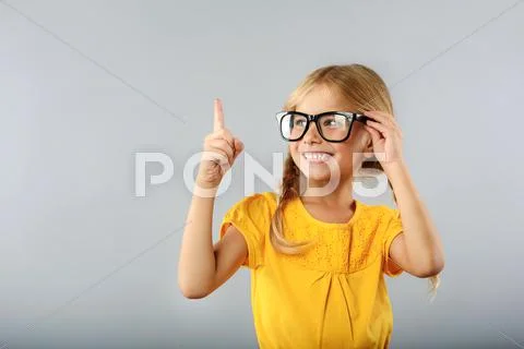 Girl pointing upwards with her index finger Stock Photos