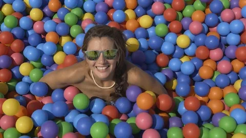 Girl in the pool with colored balls. Stock Footage 79572890